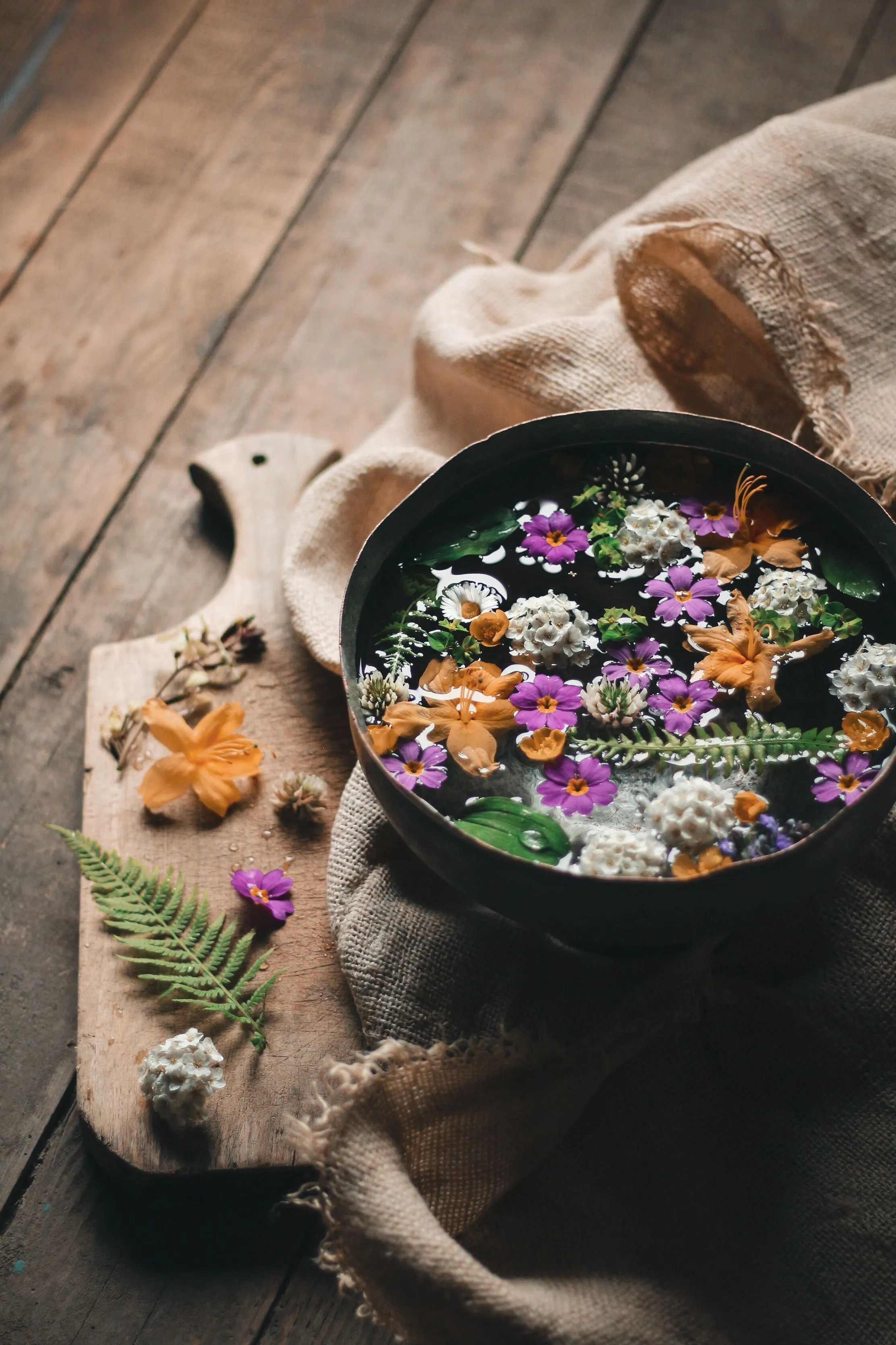 Ciotola d'acqua con fiori ed erbe spontanee per la preparazione dell'Acqua di San Giovanni